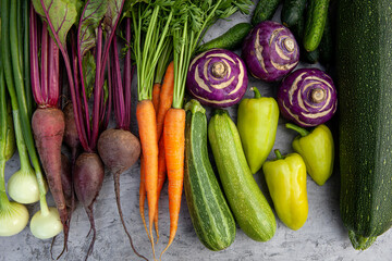 Top view of fresh vegetables - carrots, beets, zucchini, peppers, cucumbers, onions and kohlrabi cabbage - for health and cooking, wellness and nutrition. Vegan or vegetarian meal prep. Vegetables