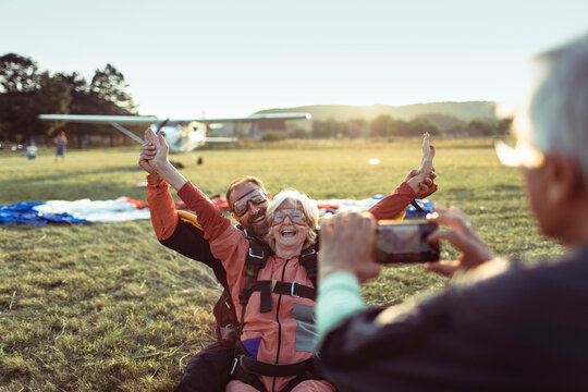 Senior woman celebrating after tandem skydiving with instructor