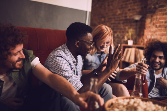 Friends laughing and having fun on a couch at a bar
