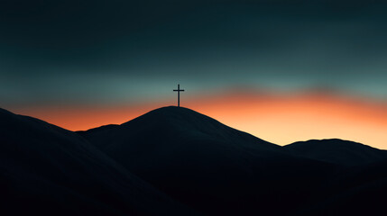 Silhouette of a cross on a hill at sunset with dramatic orange and dark blue sky