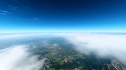 Fototapeta premium Stunning aerial view of a landscape veiled in a sea of clouds under a vibrant blue sky; a breathtaking panorama from above.