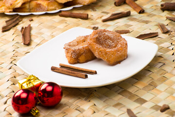 Traditional brazilian christmas Rabanadas with egg yolk crea and cinnamon, Spanish Torrijas on golden plate on a christmas dinner table