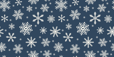Christmas and New Year seamless pattern with beautiful white snowflakes on a dark blue background. Winter illustration with falling snow.