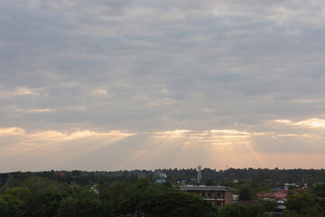 Obraz premium sky filled with clouds during either sunrise or sunset. Sunlight is breaking through the clouds in several places, creating a dramatic effect known as “God rays” or “crepuscular rays.”