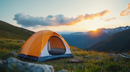 Serene camping tent nestled in a lush grassy field surrounded by towering mountains and a breathtaking sunset sky