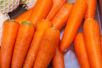 close-up view of several fresh, orange carrots placed together. The carrots are vibrant in color and appear to be clean and ready for consumption.