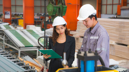 A male expertise engineering is explaining about the quality of metal sheet machine of industry to...