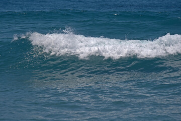 WHITE SURF ON A WAVE FORMING ON THE INDIAN OCEAN