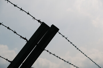 A barbed wire fence with two posts and a wire