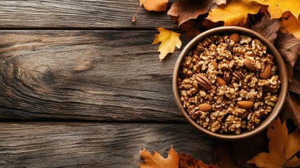 Bowl of assorted nuts nestled in vibrant autumn leaves on a rustic wooden tabletop, highlighting seasonal warmth and natural textures.