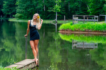 Grace by the Pond: Blonde Beauty in Black Dress Radiates Serenity and Joy in Nature