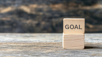 A wooden block displaying the word "GOAL" on a rustic background, symbolizing motivation and achievement.