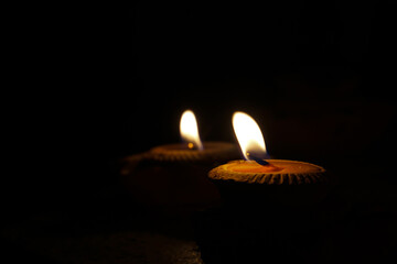 candlelight on black background of darkness at night. The burning of candles symbolizes worship, hope, encouragement, love, remembrance and relaxation. Soft and selective focus.