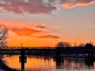 Obraz premium Silhouetted Bridge Over the River Tyne at Sunset with Vibrant Reflections
