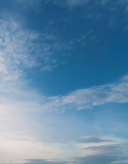Fototapeta premium High-resolution image of a serene sky with soft fluffy clouds lit by dawn's light on a pale blue background 