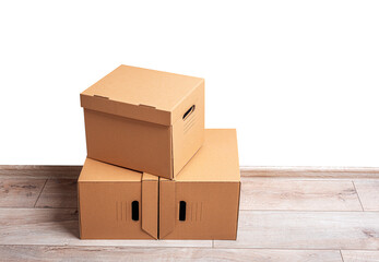 Mailing cardboard boxes on the floor against a white wall.