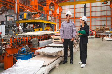 A male expertise engineering is explaining about the quality of metal sheet machine of industry to female inspector and Mechanic or technician in manufacturing or factory, Business's safety check.