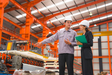A male expertise engineering is explaining about the quality of metal sheet machine of industry to female inspector and Mechanic or technician in manufacturing or factory, Business's safety check.