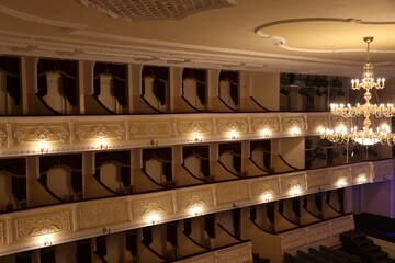 Balconies with comfortable chairs and beautiful chandelier in theatre