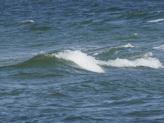 Waves on the sea during a summer day with blue sky and sunlight