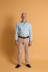 Full length portrait of senior man on beige background