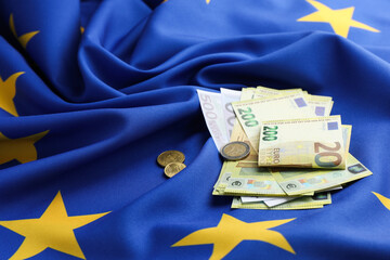 Euro banknotes and coins on European Union flag
