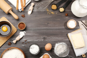 Frame of baking powder and other products on grey wooden table, flat lay. Space for text