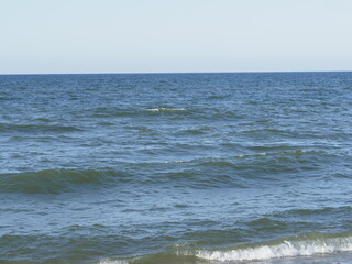 Calm sea with waves on the horizon under a clear sky