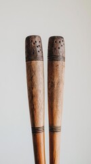 Natural wood clapsticks showcased on a plain backdrop, highlighting their design and heritage