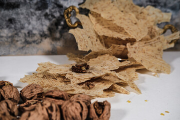 Tarhana cips, crispy snacks a traditional turkish anatolian fermented soup base made into crunchy chips made of youghurt and cereals, served with walnuts