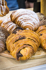 Croissant with chocolate and powder sugar on market stall or in confectionery shop