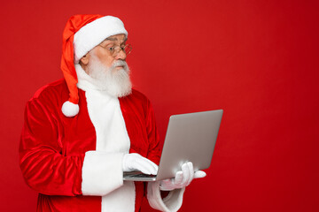 Close up photo of funny funky overweight santa claus use laptop search christmas season discounts type congratulations wear style suspenders isolated over red color background