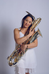 Happy female saxophonist hugging her saxophone