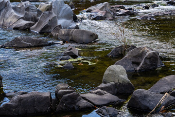 Fototapeta premium rocks and flowing stream in the autumn valley