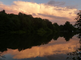 Sunset clouds and trees reflected in the calm waters of the River Thames near Boulters Lock, Maidenhead