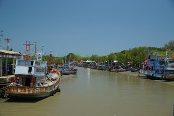 Fishing vessels docked in tranquil waterway coastal village scenic photography bright sunshine serene landscape maritime life