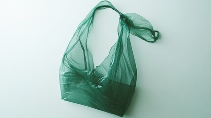 Translucent green plastic bag styled as a flowing top, gracefully draped on a soft white background, showcasing its light and airy texture.