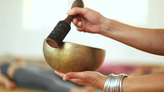 Therapist playing singing bowl during meditation