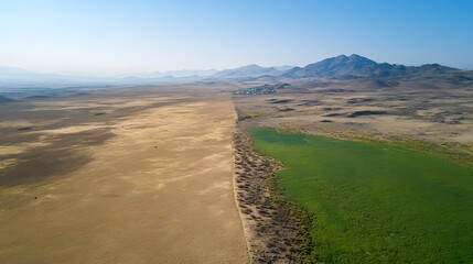 Green landscape meets dry wasteland, illustrating climate change's contrasting effects.