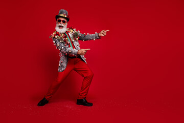 Obraz premium Photo of extravagant old man wear stylish jacket summer glasses recommend empty space isolated on red color background