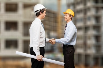 construction worker with contractor shaking hands in renovation site.