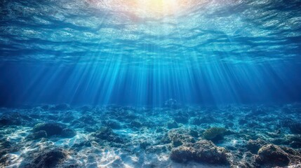Obraz premium Underwater scene with sunrays shining through the surface of the ocean.