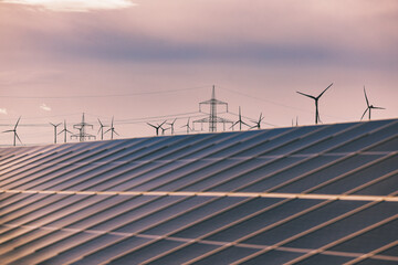 Solaranlage und Windräder bei Sonnenuntergang