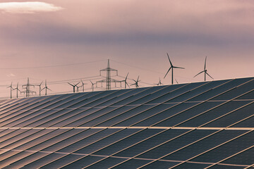 Solaranlage und Windräder bei Sonnenuntergang