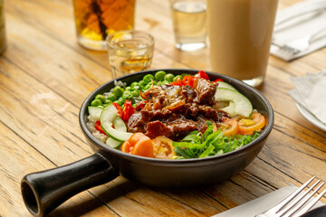 Beef Black Pepper Poke Bowl served on the table with Cappuccino and Iced Tea