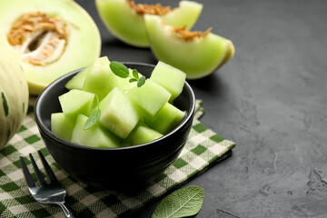 Slices of yummy melon on dark table, closeup. Space for text