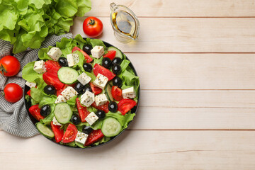 Delicious salad with feta cheese and ingredients on white wooden table, flat lay. Space for text