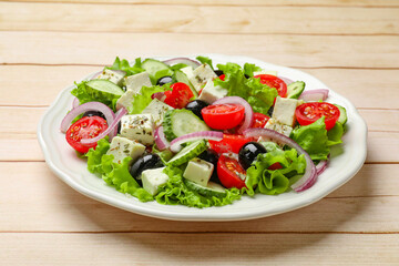 Delicious salad with feta cheese on wooden table, closeup