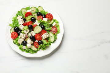 Delicious salad with feta cheese and ingredients on white table, top view. Space for text