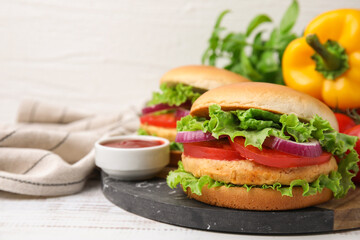 Delicious vegetarian burgers with chickpea cutlets and sauce on white wooden table, closeup